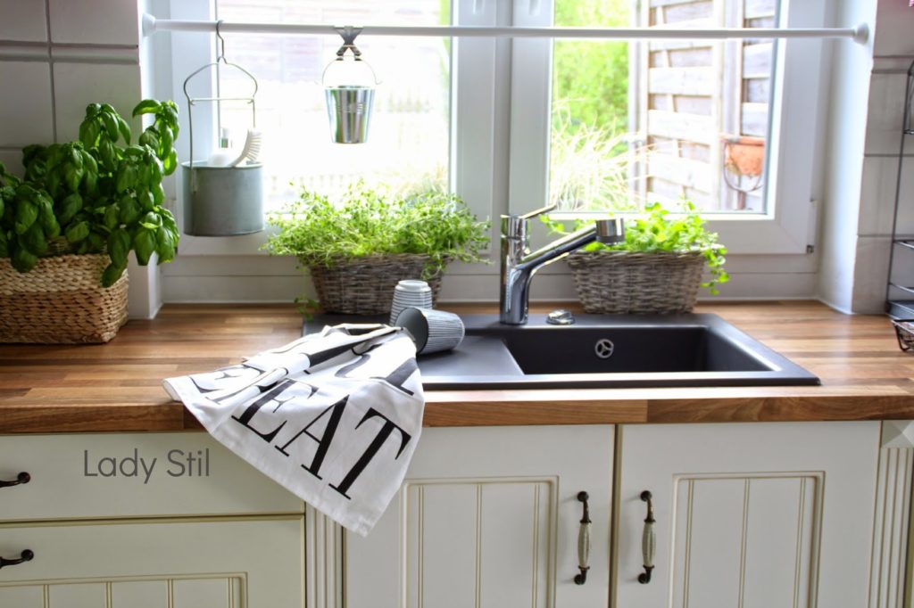 Blick auf die Küchenspüle mit zwei Bast-Kräuter-Körben und einem Geschirrhandtuch in schwarzweiß von Bloomingville sowie House Doctor Bechern in schwarzweiß gestreift