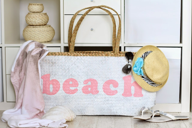 Großansicht Strandtasche mit Schriftzug Beach dekoriert mit Strandhut Sonnenbrille Flip Flops und einem Strandlaken