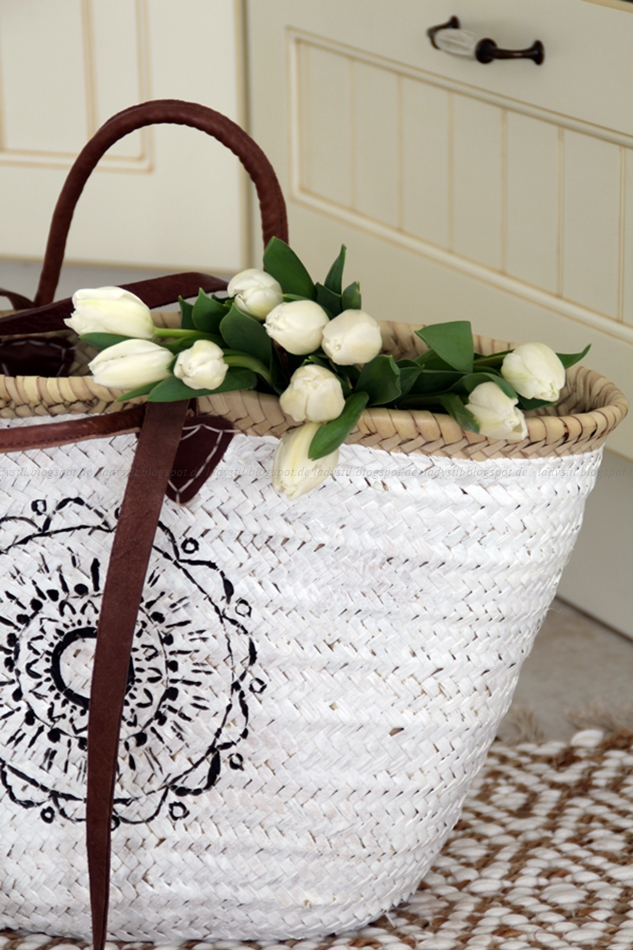Korbtasche in schwarz weiß mit Ethno Muster, es hängen Tulpen aus der Tasche heraus