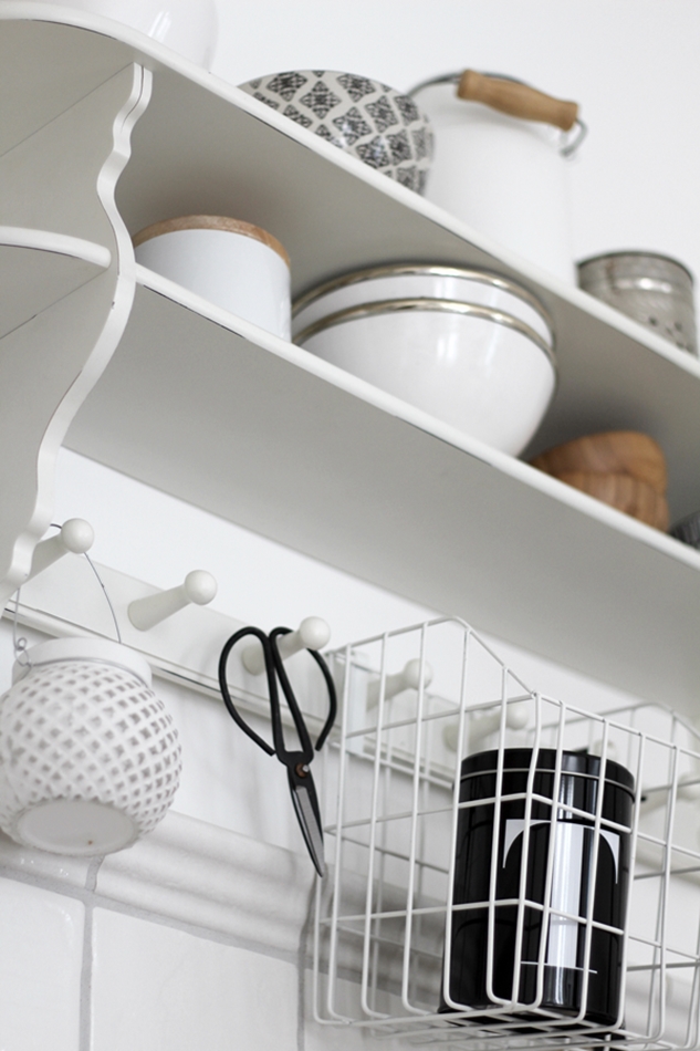 Blick auf das weiße Küchenregal mit Accessoires von House of Ideas und Dose "T" von Nicolas Vahe