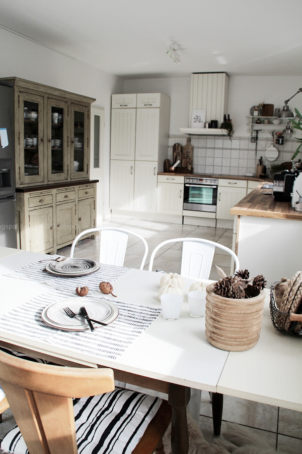 Kücheneinrichtung in Schwarz Weiß Holz mit leichten New Boho Elementen, Überblick Küche mit Zeile und Tisch