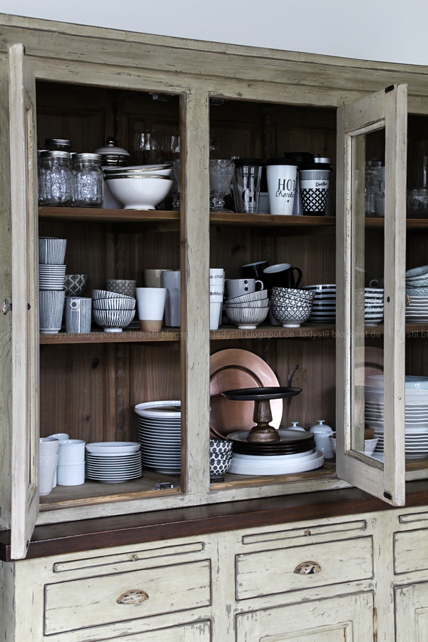 Kücheneinrichtung in Schwarz Weiß Holz mit leichten New Boho Elementen, Innenleben Schrank mit Schwarz-weißem GEschirr